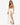 A model poses in a flowing white skirt with high slits, paired with a brown crop top and black heels.