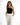 A model poses in a stylish black one-shoulder top paired with tailored white trousers.