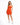 A model poses in a fitted orange dress with spaghetti straps and a cutout detail, paired with white sneakers.