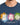 A blue t-shirt featuring three artistic symbols with colorful splashes and a positive message about kindness.