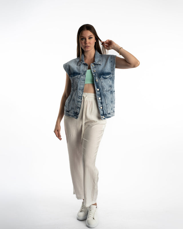 Model wearing Kinley white wide-leg utility pants with drawstring waist and a light-wash denim vest in a streetwear style.