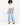 A person stands confidently in a cropped white shirt and light blue wide-leg jeans, paired with sleek black heels.