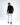 Back view of a man in a black long-sleeve streetwear shirt, white jeans, and black sneakers.