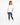 A woman stands in a relaxed pose wearing a white short-sleeve tee and distressed blue jeans with white sneakers.