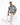 A man sits on a white pedestal, wearing a short-sleeve, blue and beige patterned shirt with white ripped jeans.