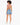 A model with curly hair wears a short-sleeve top with a back cutout, paired with denim shorts and white sneakers.