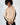 Model in Lilith beige knit sweater with black sleeve stripes and shoulder cut-outs for a fall aesthetic.