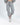 Close-up of the Lily two-piece loungewear set in light grey featuring drawstring sweatpants with seams and white sneakers.