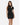 A woman poses in a fitted black dress with a high neckline and a stylish cutout on one shoulder.
