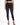 A model wearing a black crop top and high-waisted black skinny jeans, paired with strappy black heels.