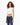 Model wearing the Luna white ribbed cropped tank top with padded shoulders and dark wash denim jeans.