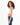 Side view of a woman in the Luna white ribbed cropped tank top with ruched detailing and dark blue denim jeans.