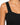 Close-up of a black ribbed top featuring wide straps and a fitted bodice, highlighting its textured fabric.