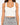 A fitted white ribbed crop top with wide straps, paired with a black and white patterned skirt.