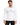 A man wearing a long-sleeve white shirt with a circular graphic and text design, paired with black ripped jeans.
