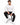 A man sits on a black stool wearing a long-sleeve white shirt with a graphic design and black ripped jeans.
