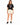 Woman in cream sweat shorts and a black graphic tee, three-quarter view