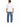 A man stands with his back to the camera, wearing a loose white t-shirt and light blue patchwork jeans.