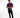 A man stands confidently in a purple short-sleeve shirt and black jeans, wearing white sneakers.