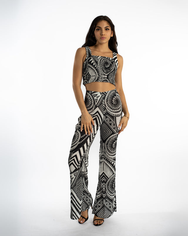Model in Marlee black knit crop top and matching tribal print flare pants for a streetwear aesthetic OOTD.