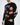 A man is wearing a black long-sleeve shirt with colorful graphic designs and playful text.