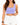 A model wears a fitted lavender crop top paired with white high-waisted shorts, showcasing a casual summer look.
