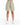 Light green high-waisted shorts with a tie belt and pleated front, paired with white sneakers.