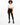 A woman with curly hair stands confidently in black leggings and a cropped white top, paired with stylish boots.