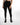 A person wearing form-fitting black leggings paired with stylish black ankle boots, standing against a white background.