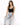 A model poses in light blue ripped jeans and a black cropped top, showcasing a casual, stylish look.
