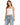 A woman stands confidently in light blue distressed jeans with a drawstring waist and a fitted white top.