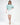 Model wearing the More and Less teal knit cropped sweatshirt and a white mini skirt against a white background.