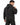 A man in a dark hoodie stands with his back turned, showcasing the hood and relaxed fit.