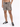 Male model wearing leopard print shorts with an elastic waistband and black sneakers, standing against a white backgr...