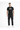 A man stands confidently in a black graphic t-shirt and cargo pants, paired with white sneakers.
