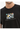 A close-up of a black t-shirt featuring a colorful geometric pattern and a handwritten-style text design.