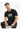 A man wearing a black t-shirt with a colorful geometric design sits casually, showcasing a relaxed style.