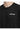 Close-up of a black crewneck shirt featuring white text that reads "challenge" on the chest area.