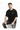 A man sits on a white pedestal wearing a black oversized t-shirt and distressed jeans, showcasing a casual style.