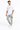 A man stands confidently wearing a white graphic t-shirt and light green cargo pants with pockets.