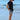 Man on beach wearing Carter patterned swim trunks and black t-shirt, showing trendy summer swimwear style.
