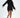 A model showcases a black oversized hoodie dress with a unique hemline and side slits, paired with stylish black ankl...