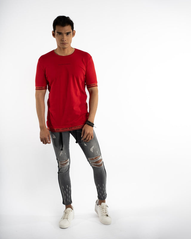 A model wearing a red short-sleeve shirt and distressed gray skinny jeans, paired with white sneakers.