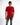 A model wearing a fitted red t-shirt with black text and distressed gray jeans, posing against a white background.
