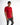 A model poses in a fitted red shirt with contrasting black and orange text on the sleeves and hem, paired with distre...