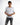 A young man wearing a fitted white t-shirt with graphic text and distressed gray jeans, posing confidently.