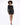 A model showcases a fitted black sequin dress with long sleeves and a boat neckline, paired with black heels.