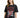 A woman in a black oversized tee featuring a graphic design with flames, a heart, and bold text.
