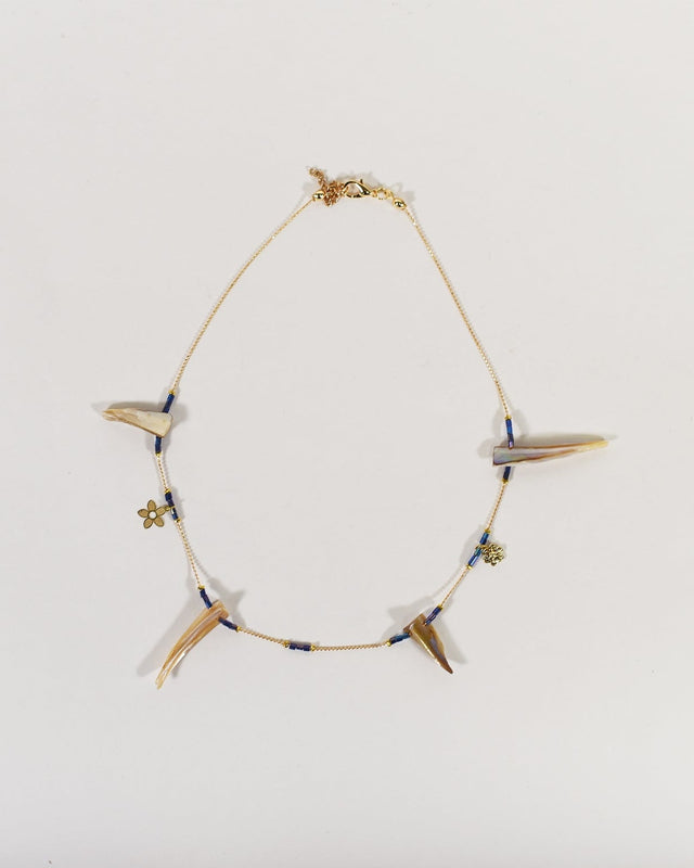 Minimalist gold chain necklace featuring iridescent shell charms, small blue beads, and gold flower accents.