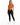 A woman stands confidently in a cropped, rust-colored top tied at the waist, paired with black leggings and white sne...